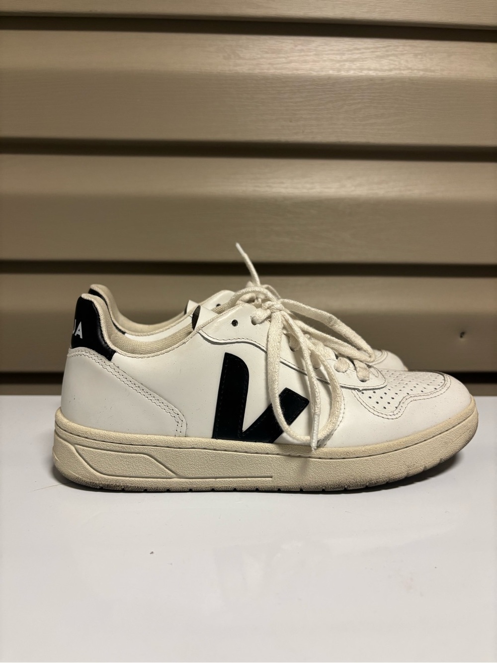 veja white sneakers with black V logo.